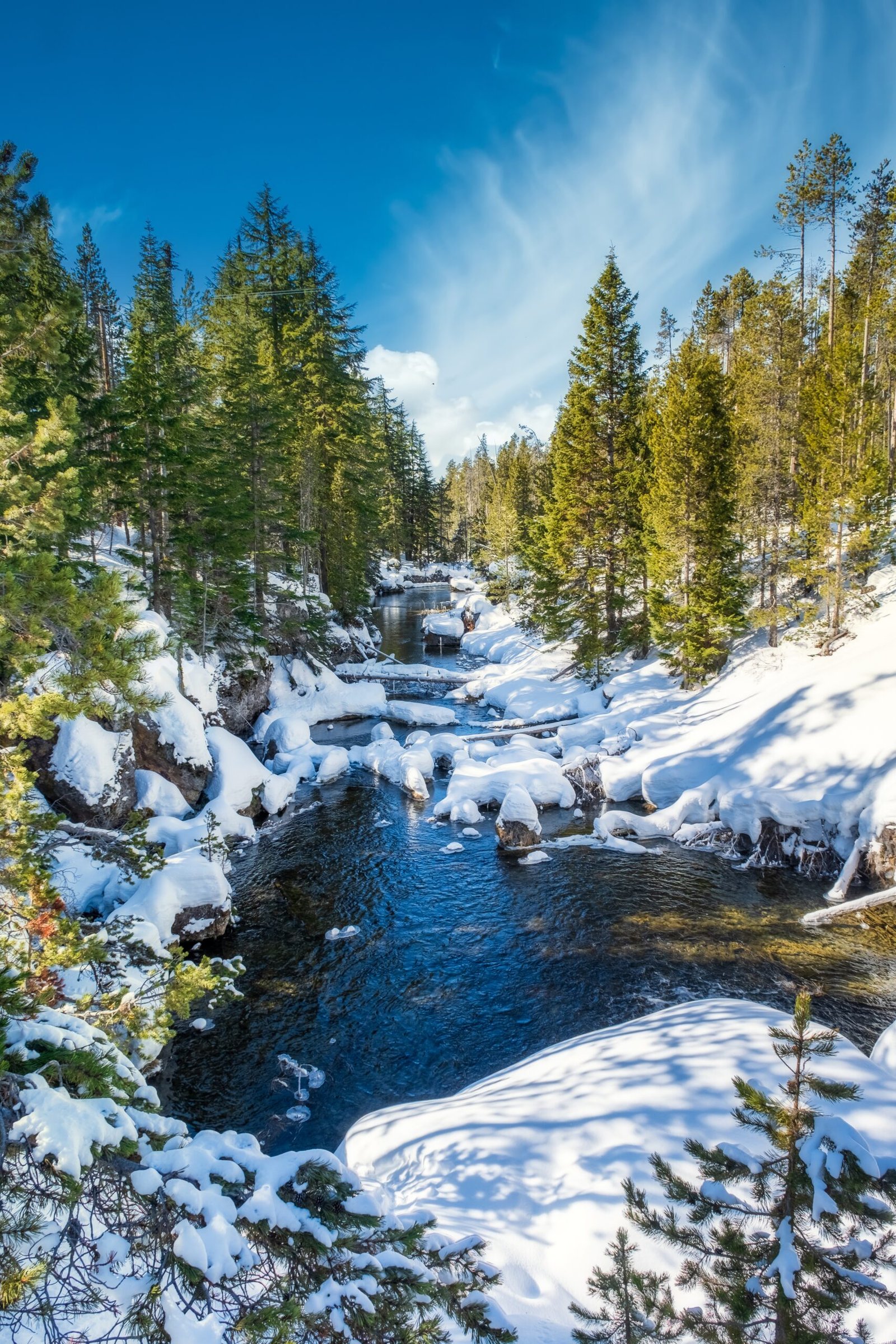 A mesmerizing shot of a beautiful snowy rocky park around  the lake with a background of a mountain